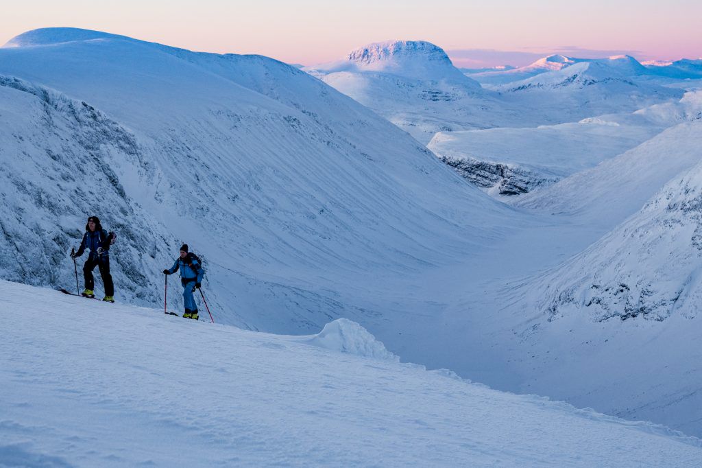 Kristofer Turdell och Peter Nilsson närmar sig toppen av Tuolpagorni. Solen är på väg upp. Foto: Emrik Jansson